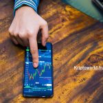 Hand man and Stock market chart on mobile screen.